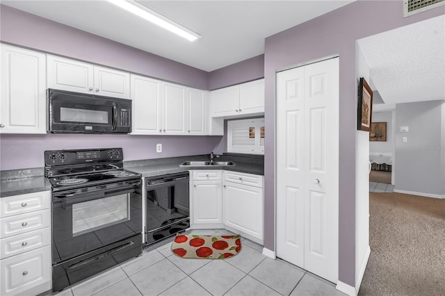 6916 Stones Throw Cir N Unit 9207, Saint Petersburg, FL 33710 - kitchen with black appliances, dark countertops, white cabinets, and light tile patterned flooring