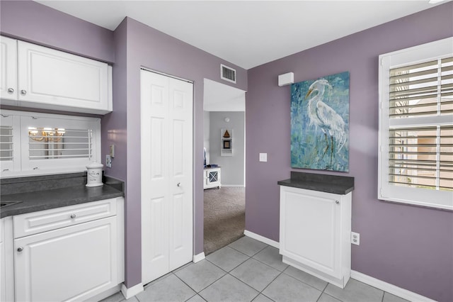 6916 Stones Throw Cir N Unit 9207, Saint Petersburg, FL 33710 - kitchen featuring dark countertops, white cabinets, and light tile patterned flooring