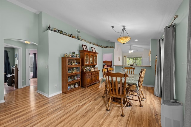 5112 Prairie View Way, Wesley Chapel, FL 33545 - dining space with light wood-style floors, arched walkways, and ceiling fan