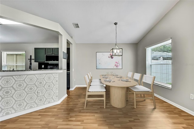 19635 Bellehurst Loop, Land O Lakes, FL 34638 - dining room with light wood-style flooring and vaulted ceiling