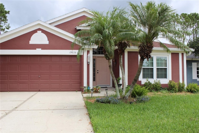19635 Bellehurst Loop, Land O Lakes, FL 34638 - view of front of house with stucco siding, a garage, concrete driveway, and a front yard