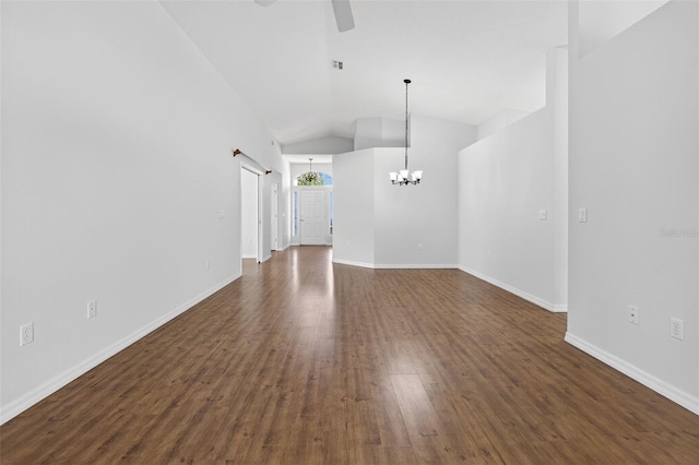 11348 Tee Time Cir, New Port Richey, FL 34654 - unfurnished living room with ceiling fan, a chandelier, dark wood-type flooring, and vaulted ceiling