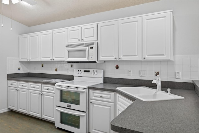 11348 Tee Time Cir, New Port Richey, FL 34654 - kitchen with white appliances, dark countertops, and white cabinets