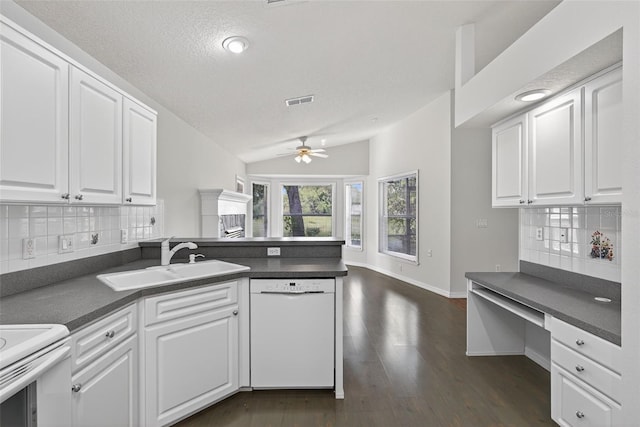 11348 Tee Time Cir, New Port Richey, FL 34654 - kitchen with white appliances, a ceiling fan, a peninsula, dark countertops, and decorative backsplash