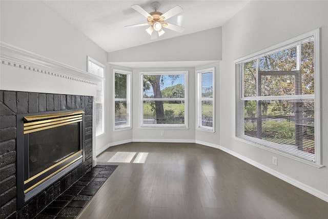 11348 Tee Time Cir, New Port Richey, FL 34654 - unfurnished living room featuring a fireplace, dark wood-type flooring, lofted ceiling, and ceiling fan