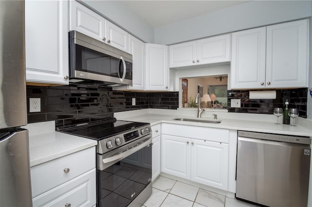 1701 Pinehurst Rd Unit 24B, Dunedin, FL 34698 - kitchen featuring appliances with stainless steel finishes, light countertops, white cabinets, and backsplash