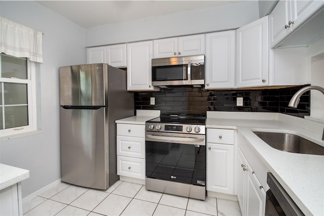 1701 Pinehurst Rd Unit 24B, Dunedin, FL 34698 - kitchen featuring appliances with stainless steel finishes, backsplash, and white cabinetry