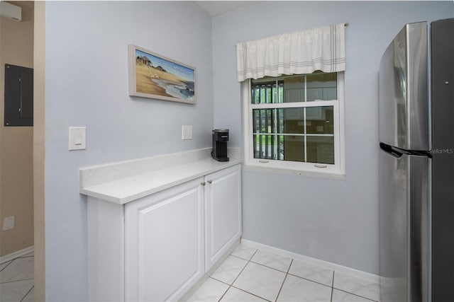 1701 Pinehurst Rd Unit 24B, Dunedin, FL 34698 - kitchen with freestanding refrigerator, electric panel, light countertops, light tile patterned flooring, and white cabinets