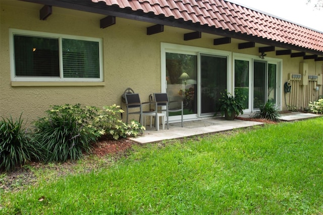 1701 Pinehurst Rd Unit 24B, Dunedin, FL 34698 - back of house featuring stucco siding, a yard, and a patio area