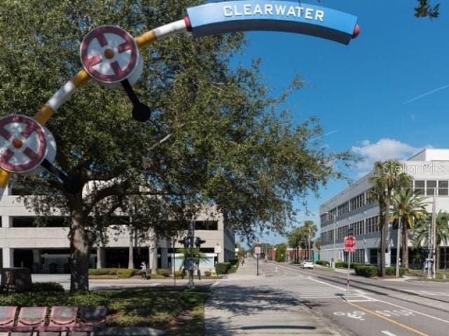 1701 Pinehurst Rd Unit 24B, Dunedin, FL 34698 - view of asphalt road with traffic signs, sidewalks, street lights, and curbs