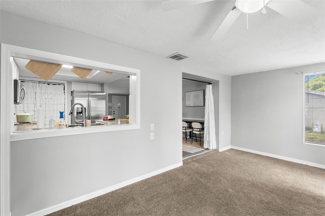 8004 Beaver Creek Loop, Hudson, FL 34667 - unfurnished living room featuring carpet floors, ceiling fan, and a textured ceiling
