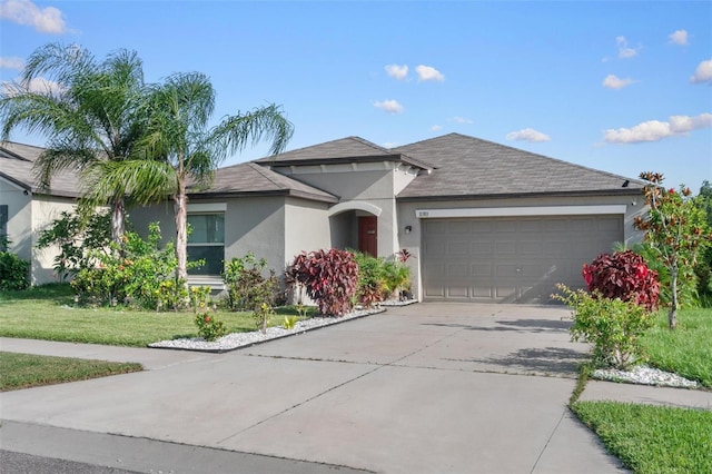 11303 Misty Moss Dr, Wimauma, FL 33598 - ranch-style house with stucco siding, driveway, an attached garage, a front yard, and roof with shingles