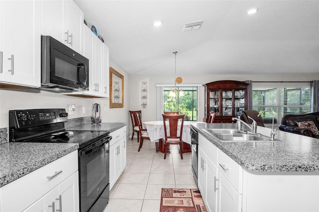 11303 Misty Moss Dr, Wimauma, FL 33598 - kitchen featuring black appliances, vaulted ceiling, light tile patterned floors, open floor plan, and white cabinets