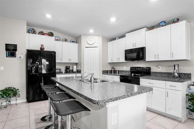 11303 Misty Moss Dr, Wimauma, FL 33598 - kitchen with black appliances, light tile patterned floors, a kitchen bar, white cabinets, and recessed lighting