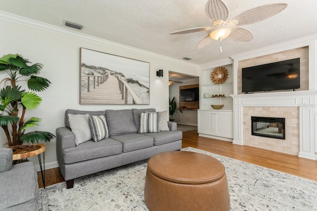 1304 63rd St NW, Bradenton, FL 34209 - living area featuring ornamental molding, a ceiling fan, wood finished floors, a textured ceiling, and a fireplace