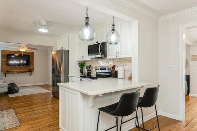 1304 63rd St NW, Bradenton, FL 34209 - kitchen with appliances with stainless steel finishes, a ceiling fan, light wood-style floors, tasteful backsplash, and crown molding