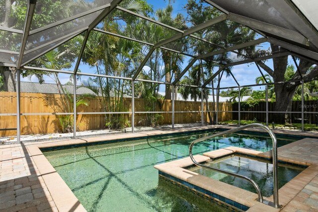 1304 63rd St NW, Bradenton, FL 34209 - view of swimming pool with a fenced backyard, glass enclosure, and a pool with connected hot tub