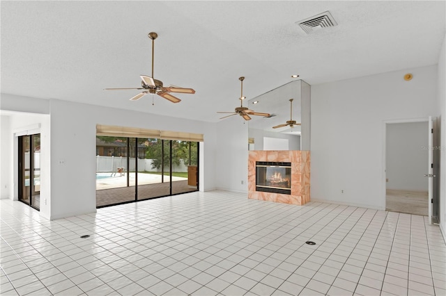 9311 136th Way, Seminole, FL 33776 - unfurnished living room with ceiling fan, a fireplace, vaulted ceiling, and light tile patterned floors