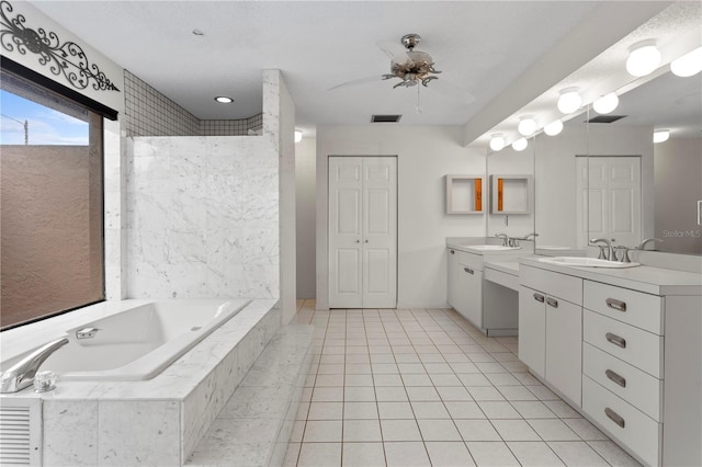 9311 136th Way, Seminole, FL 33776 - bathroom with two vanities, a bath, a ceiling fan, and tile patterned floors