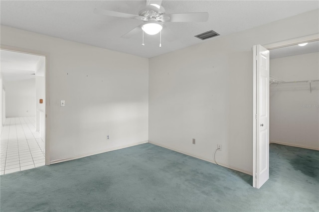 9311 136th Way, Seminole, FL 33776 - unfurnished bedroom with carpet floors, a walk in closet, a ceiling fan, and a closet