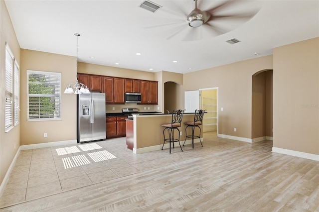 221 Sunset Crest Ct, Apollo Beach, FL 33572 - kitchen with appliances with stainless steel finishes, arched walkways, a kitchen breakfast bar, a ceiling fan, and recessed lighting