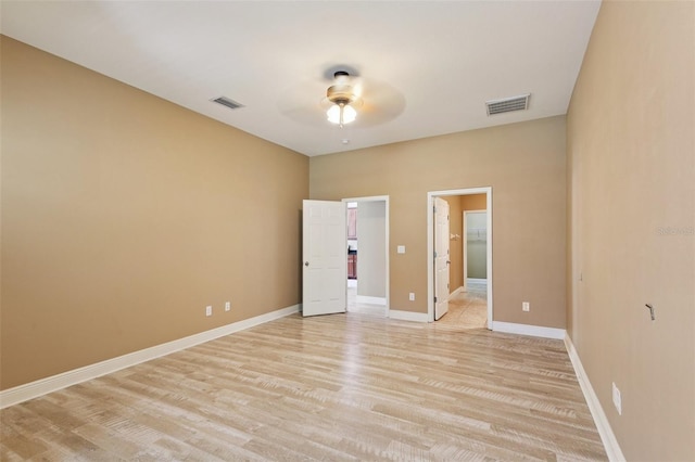 221 Sunset Crest Ct, Apollo Beach, FL 33572 - unfurnished bedroom featuring light wood-type flooring, a spacious closet, ensuite bath, and ceiling fan