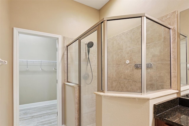 221 Sunset Crest Ct, Apollo Beach, FL 33572 - full bathroom featuring a shower stall, a spacious closet, and wood finished floors
