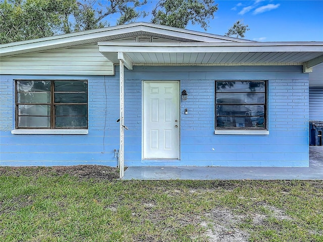 6228 Florida Cir W, Apollo Beach, FL 33572 - doorway to property with a yard and brick siding