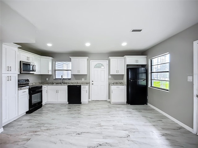 6228 Florida Cir W, Apollo Beach, FL 33572 - kitchen with black appliances, white cabinets, light marble finish flooring, light stone counters, and recessed lighting