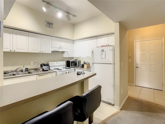 501 S Moody Ave Unit 1130, Tampa, FL 33609 - kitchen with white appliances, under cabinet range hood, white cabinets, and a breakfast bar area