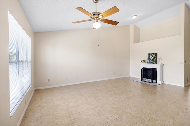 2231 Utopian Dr E Unit 307, Clearwater, FL 33763 - unfurnished living room featuring light tile patterned floors, a fireplace with raised hearth, ceiling fan, a textured ceiling, and high vaulted ceiling