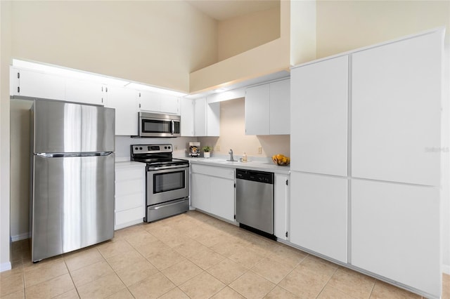 2231 Utopian Dr E Unit 307, Clearwater, FL 33763 - kitchen featuring stainless steel appliances, a towering ceiling, light countertops, white cabinets, and light tile patterned floors