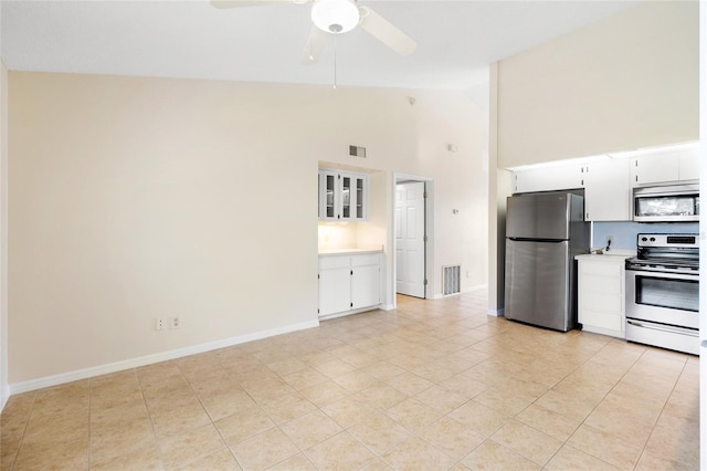 2231 Utopian Dr E Unit 307, Clearwater, FL 33763 - kitchen with stainless steel appliances, high vaulted ceiling, light countertops, white cabinets, and ceiling fan