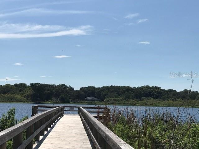 2231 Utopian Dr E Unit 307, Clearwater, FL 33763 - dock area featuring a wooded view and a water view