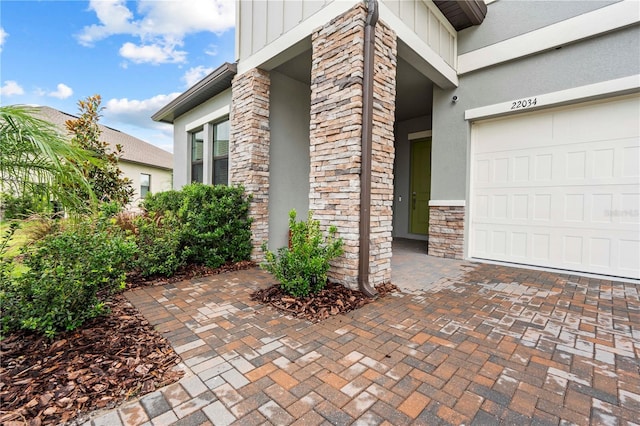 22034 Storybook Cabin Way, Land O Lakes, FL 34637 - property entrance featuring stone siding, stucco siding, and board and batten siding