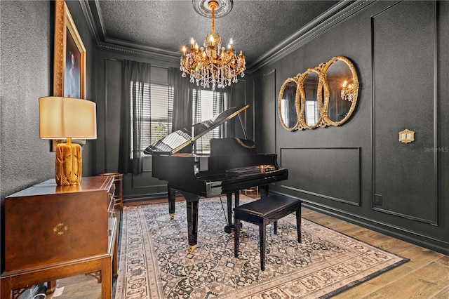 22034 Storybook Cabin Way, Land O Lakes, FL 34637 - living area featuring ornamental molding, a chandelier, wood finished floors, a textured ceiling, and a textured wall