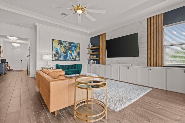 22034 Storybook Cabin Way, Land O Lakes, FL 34637 - living area with ornamental molding, wood finished floors, ceiling fan, a chandelier, and an accent wall