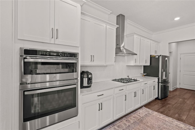 22034 Storybook Cabin Way, Land O Lakes, FL 34637 - kitchen with stainless steel appliances, wall chimney range hood, light countertops, dark wood-style floors, and white cabinetry