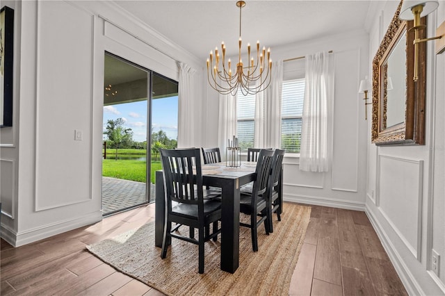 22034 Storybook Cabin Way, Land O Lakes, FL 34637 - dining area with a chandelier, wood-type flooring, healthy amount of natural light, ornamental molding, and a water view