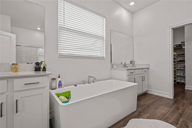 22034 Storybook Cabin Way, Land O Lakes, FL 34637 - full bathroom featuring wood finished floors, vanity, a freestanding tub, a spacious closet, and recessed lighting