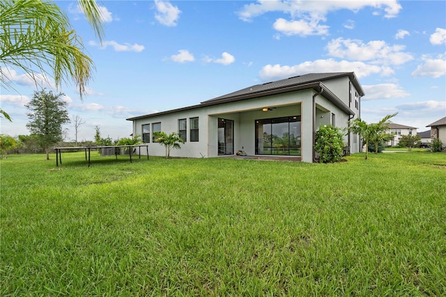 22034 Storybook Cabin Way, Land O Lakes, FL 34637 - rear view of property featuring stucco siding and a lawn
