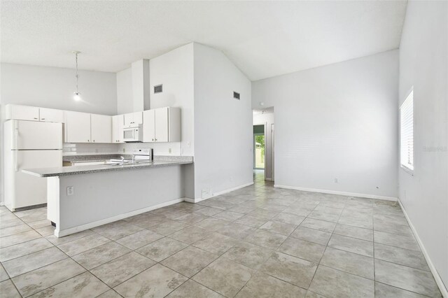 12315 Hidden Brook Dr, Tampa, FL 33624 - kitchen with white appliances, high vaulted ceiling, healthy amount of natural light, a peninsula, and white cabinetry