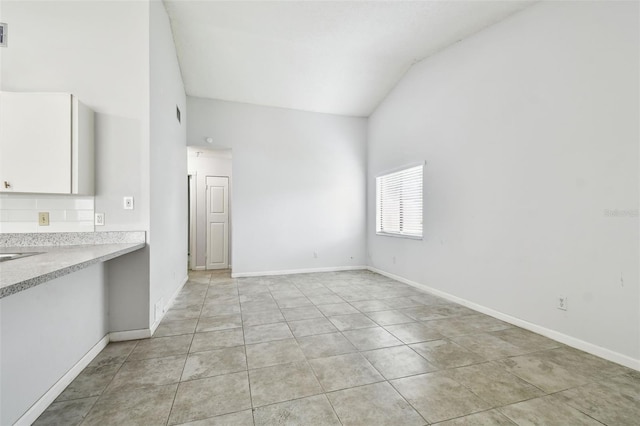 12315 Hidden Brook Dr, Tampa, FL 33624 - unfurnished living room featuring vaulted ceiling and light tile patterned floors
