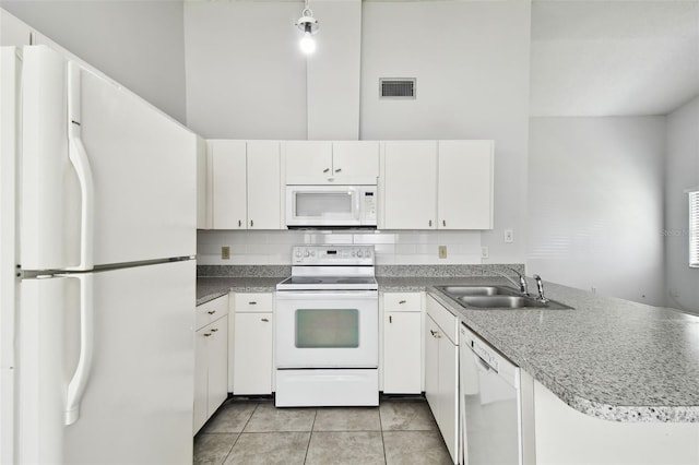 12315 Hidden Brook Dr, Tampa, FL 33624 - kitchen featuring white appliances, a peninsula, white cabinetry, and light tile patterned floors