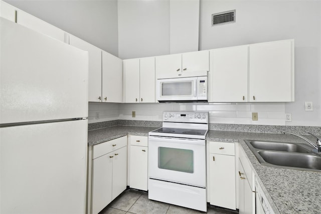 12315 Hidden Brook Dr, Tampa, FL 33624 - kitchen featuring white appliances, white cabinets, backsplash, and light tile patterned floors