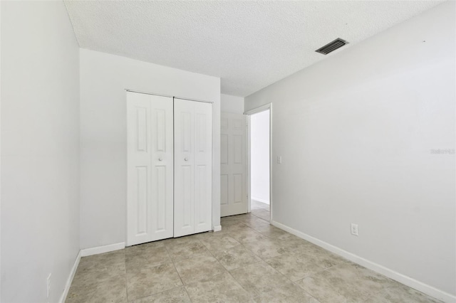 12315 Hidden Brook Dr, Tampa, FL 33624 - unfurnished bedroom with a closet and a textured ceiling