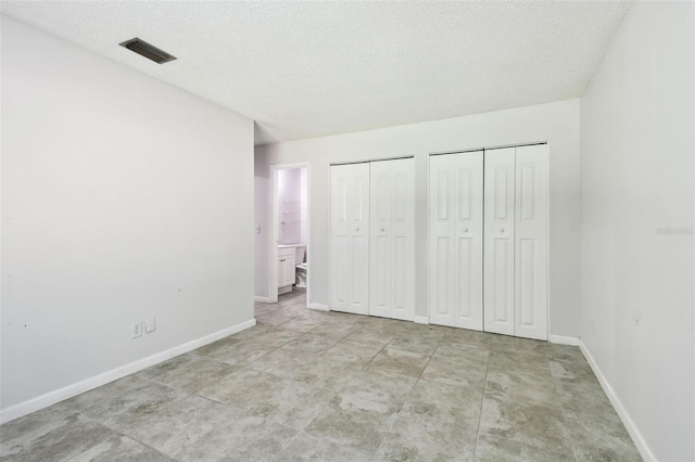 12315 Hidden Brook Dr, Tampa, FL 33624 - unfurnished bedroom with two closets and a textured ceiling
