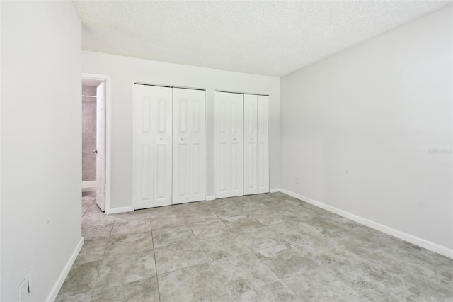 12315 Hidden Brook Dr, Tampa, FL 33624 - unfurnished bedroom with two closets, ensuite bathroom, and a textured ceiling