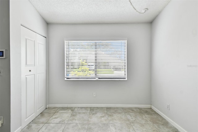 12315 Hidden Brook Dr, Tampa, FL 33624 - unfurnished room featuring a textured ceiling and light tile patterned flooring