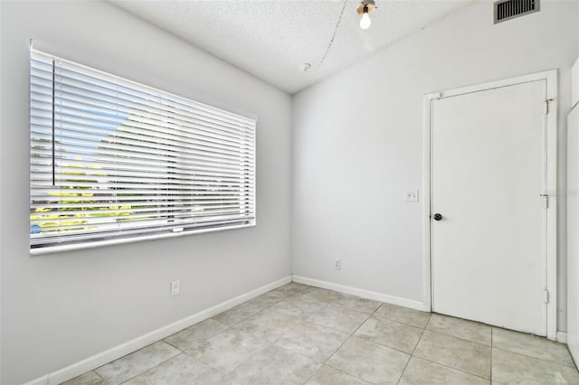 12315 Hidden Brook Dr, Tampa, FL 33624 - unfurnished room featuring a textured ceiling and light tile patterned flooring